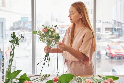 Woman making tender fresh flower bouquet