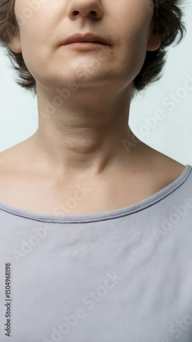Close up of a woman's neck and chest area, displaying aging skin concerns and cosmetic skin problems. Portrait shot with natural light, neutral tones.