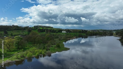 Wallpaper Mural Hope Castle, County Monaghan, Ireland, September 2022. Drone approach over cloudy sky of Lough Muckno with building watching over lake shore with grass reeds growing on edge. Torontodigital.ca