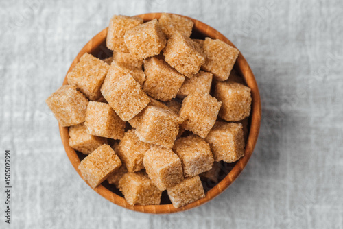Foto Sugar cubes arranged in a wooden bowl on a neutral surface