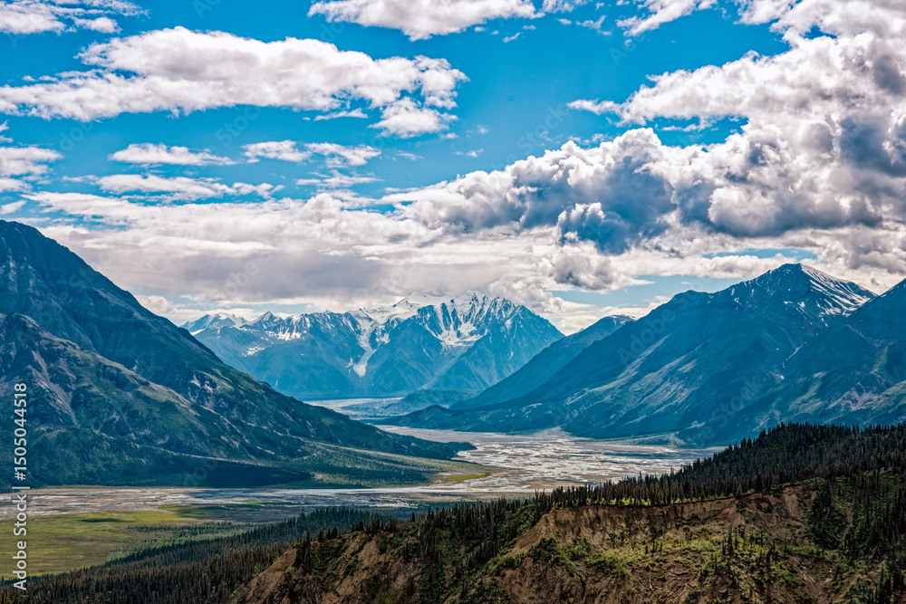 Fototapeta premium The Slims River flows below the snowy mountains viewed from Sheep Creek Trail at Kluane National Park, Yukon, Canada
