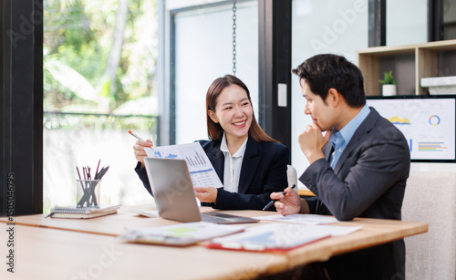 Team of Asian business people point to graphs and charts to analyze market data, balance sheet, account, net profit to plan new sales strategies to increase production capacity.
