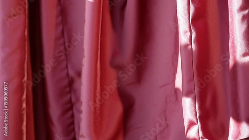 a red curtain, gently moving as if stirred by a light breeze