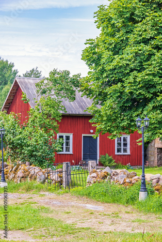 Idyllic red cottage with a gate into the garden