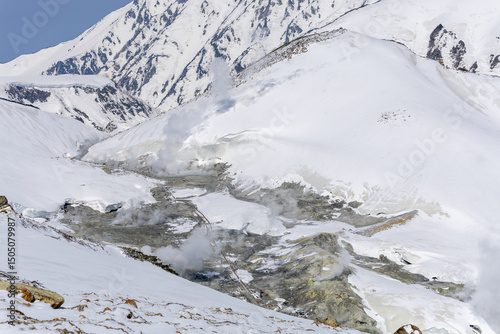 雪に覆われた地獄谷から噴き出す火山性の蒸気
立山の雪原に広がる地獄谷から火山性の蒸気が立ち上り、険しい高山地形と調和する幻想的な風景。
