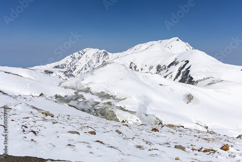 雪に覆われた地獄谷から噴き出す火山性の蒸気
立山の雪原に広がる地獄谷から火山性の蒸気が立ち上り、険しい高山地形と調和する幻想的な風景。
