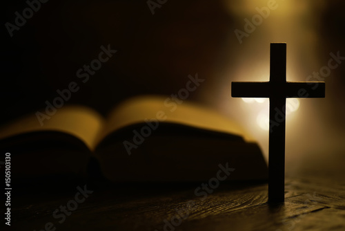 Fotografie Silhouette of Wooden Cross with Open Bible in Warm Candlelight