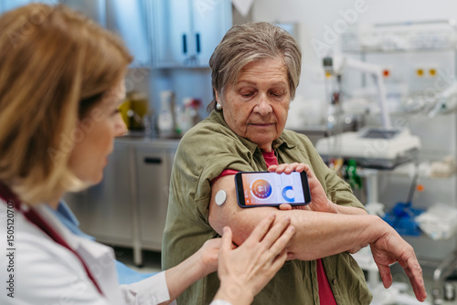 Endocrinologist teaching older patient how to connect continuous glucose monitor with mobil app.
