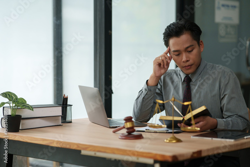 lawyer sits reading a book studying the law in a law office.