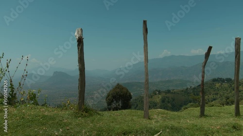 Mountainous areas of Great Rift valley and sparse settlements at foot. Logs in ground show boundaries of locals' farmland. Beautiful panorama of green ridges in haze