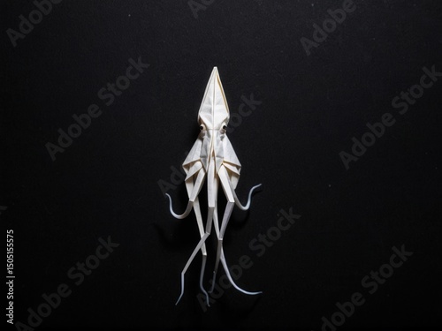  A solitary origami squid gracefully contrasts against a pitch-black abyss