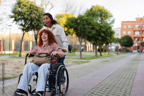 Wallpaper Mural Young woman assisting another woman in a wheelchair outdoors in a park Torontodigital.ca