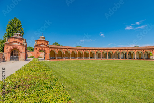 the middle of Monumental cemetery of Ferraraof Italy, the Charterhouse of Ferrara. In Italy it features a curved portico with arches and columns surrounding a green lawn.