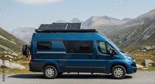 Blue Camper Van with Solar Panels Parked in Front of Mountainous Landscape