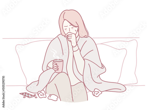 A woman sits on her couch, wrapped in a warm blanket, enjoying a hot drink, feeling cozy and relaxed
