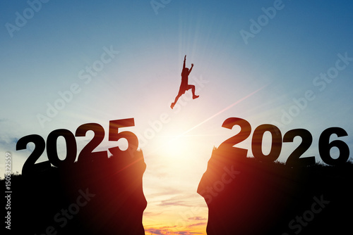 Welcome merry Christmas and happy new year in 2026,Silhouette Man jumping from 2025 cliff to 2026 cliff with cloud sky and sunlight.