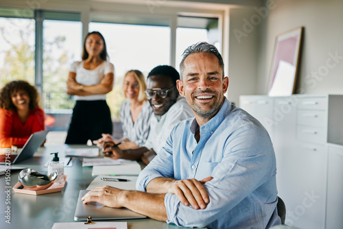 Smiling diverse Business Team in a Modern Office Setting Having a Meeting. They are all happy and positive as they look directly into the camera with a big smile.