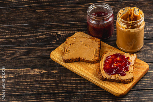 Peanut butter and jelly sandwich preparation on wooden board