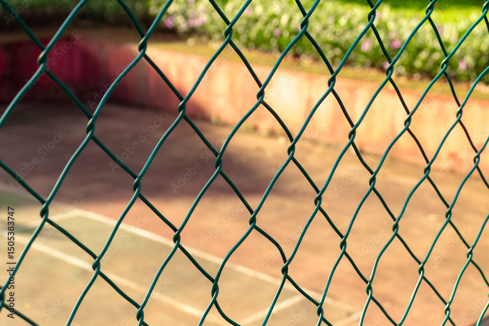 Fototapeta premium Fences with tennis court in the background on a sunny day. After edits. 