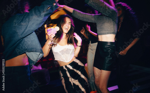 Friends having fun and dancing at a club with vibrant nightlife vibes photo