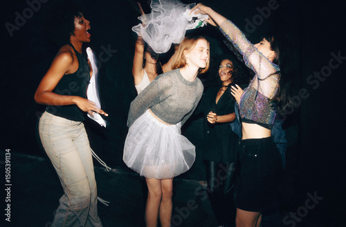 Group of friends dancing and celebrating a special occasion outdoors photo