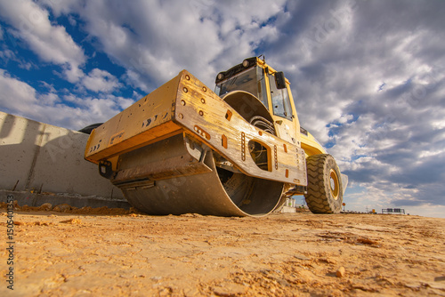 Steamroller performing leveling work on a road under construction