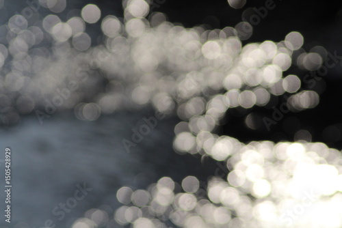 Beautiful shiny silver river background. Beautiful silver water bokeh background. Christmas lights in bokeh. Outside in December. Silver bokeh on a black background. bokeh abstract backdrop, Xmas
 photo