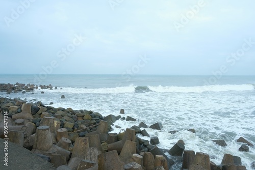 The breakwater at beach on cloudy day. Made from concrete mold. Sea and wave breakers. Pemecah ombak, pemecah gelombang laut