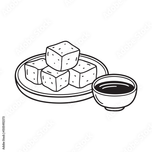 Tofu cubes beside soy sauce in a dipping bowl