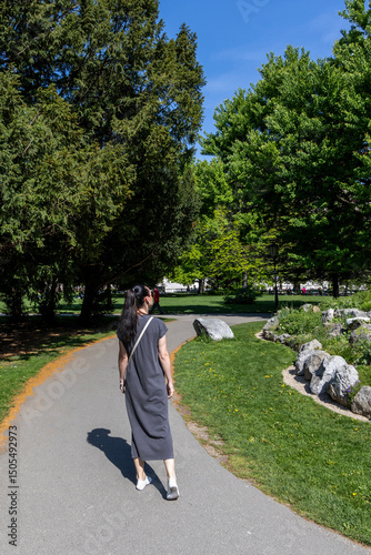 Girl tourist walking in green park. Back view. Austria, Vienna