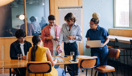 Group of colleagues discussing a project around a wooden table