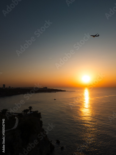 Aerial view of the sun rising over the ocean, light glimmering across the surface as waves move slowly. Perfect for cinematic openings, travel reels, or nature documentaries.
