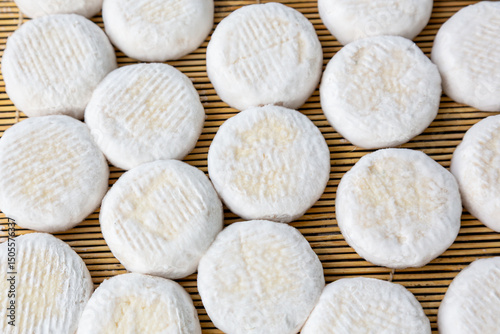 Small heads of crottin goat cheese  on a bamboo sticks.