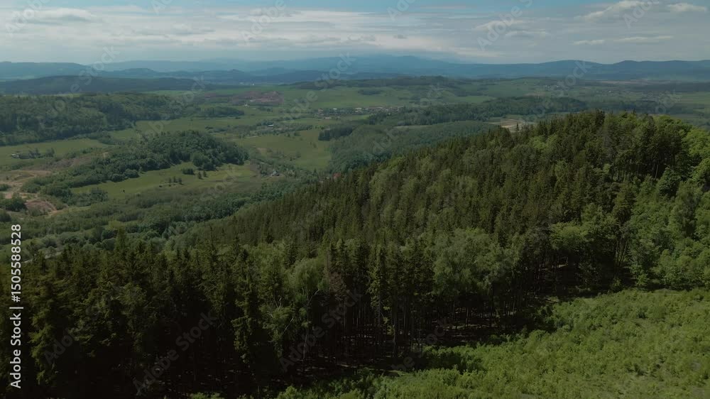 Aerial view of dense green forest and open terrain spreading across hills and valleys around Chełmiec mountain near Boguszów-Gorce in Lower Silesia Aerial view of dense green forest and open terrain spreading across hills and valleys around Chełmiec mountain near Boguszów-Gorce in Lower Silesia
