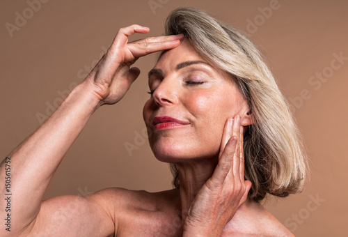 Beauty portrait of beautiful mature woman, concepts about cosmetics, skincare and wellness. Mature woman touching face showing wellness and skincare routine