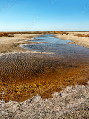 A watercourse of varying degrees of salinity from a hypersalted lake. The bitter-salty river. A dead transparent segment