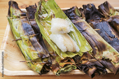 Delectable Charcoal Grilled Thai Sweetened Sticky Rice with Fillings Wrapped in Banana Leaf Called Khao Niao Ping photo