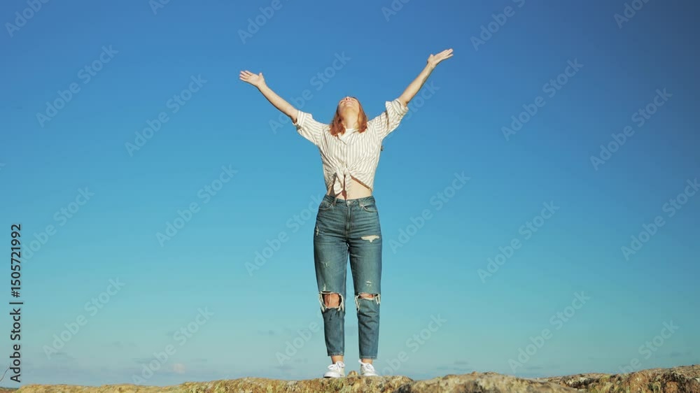 Woman embracing freedom, standing on rocky hilltop with outstretched arms, radiating joy while connecting with expansive blue sky and pristine natural landscape.Europe travel. Lifestyle, vacation Woman embracing freedom, standing on rocky hilltop with outstretched arms, radiating joy while connecting with expansive blue sky and pristine natural landscape.Europe travel. Lifestyle, vacation