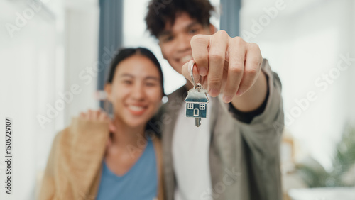 Fotografie Close-up Young happy Asian sweet couple hug each other smiling looking at camera so proud show off new house keychain in living room