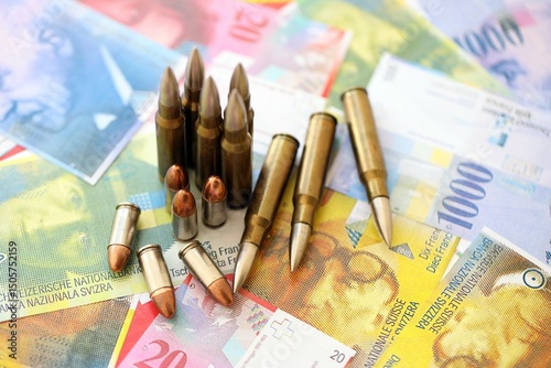 Swiss franc banknotes and bullets. The current francs money bills and ammo lies on table photo
