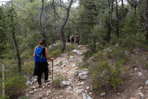 Group of hikers hiking in a nature trail. People trekking outdoors. Active healthy lifestyle photo
