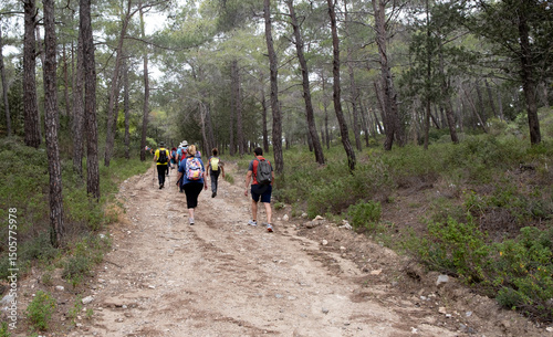 Group of hikers hiking in a nature trail. People trekking outdoors. Active healthy lifestyle photo