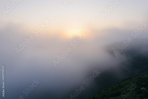 Misty Mountain Landscape at Dawn with Clouds and Fading Light