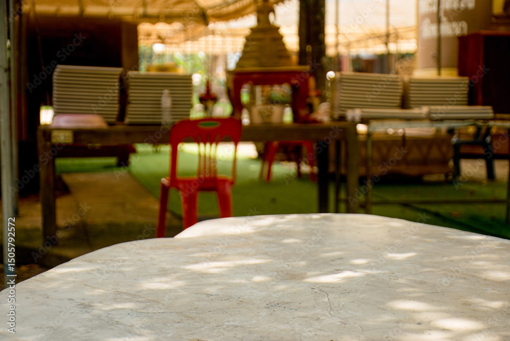 Fototapeta premium Sunlit Stone Tabletop with Blurred Background of Outdoor Setting, White marble table for product display.