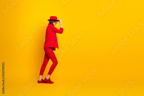 Canvastavla Young woman in a striking red outfit posing against a vibrant yellow background
