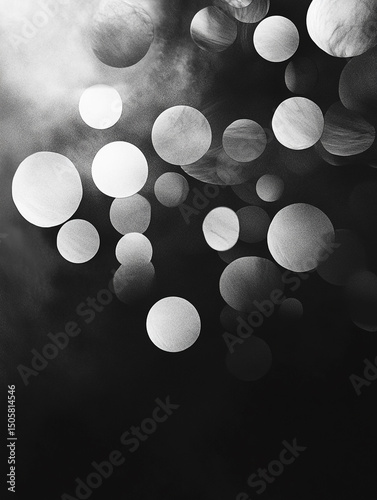 An abstract black and white image features a collection of translucent, overlapping bubbles of varying sizes. The bubbles are scattered across a dark background, creating a sense of depth and movement