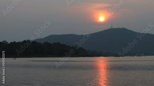Natural video background of a high-angle atmosphere on a mountain that overlooks the surrounding scenery(mountains, trees,sea)from a scenic vantage point,with a wooden chair for sitting and resting photo