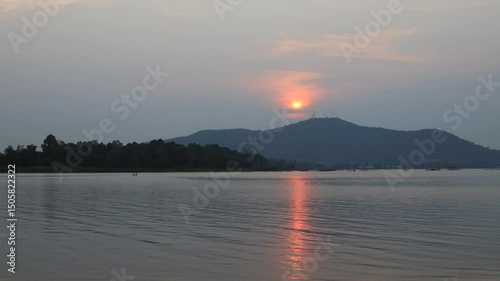 Natural video background of a high-angle atmosphere on a mountain that overlooks the surrounding scenery(mountains, trees,sea)from a scenic vantage point,with a wooden chair for sitting and resting photo