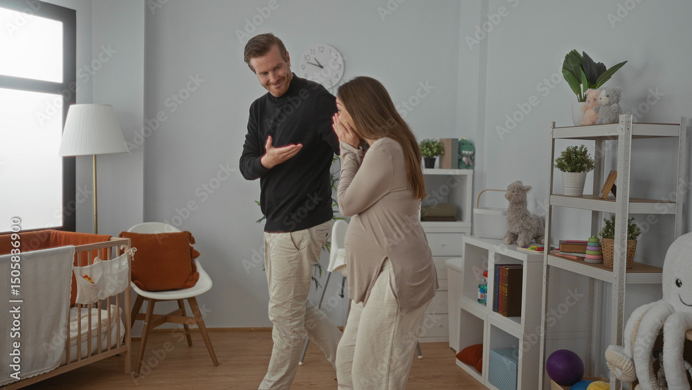 Fototapeta premium Pregnant woman with a man in a cozy baby room featuring a crib, toys, and decor, sharing a joyful moment at home.