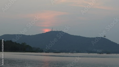 Natural video background of a high-angle atmosphere on a mountain that overlooks the surrounding scenery(mountains, trees,sea)from a scenic vantage point,with a wooden chair for sitting and resting photo